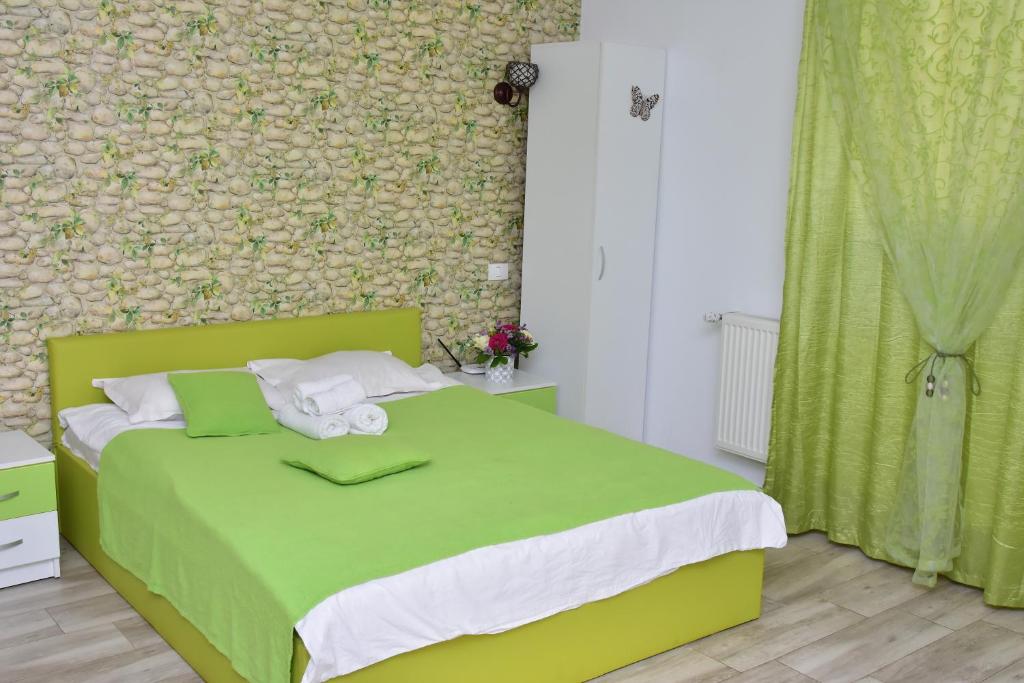uma cama verde num quarto com uma parede verde em Cazare Fundeni em Bucareste