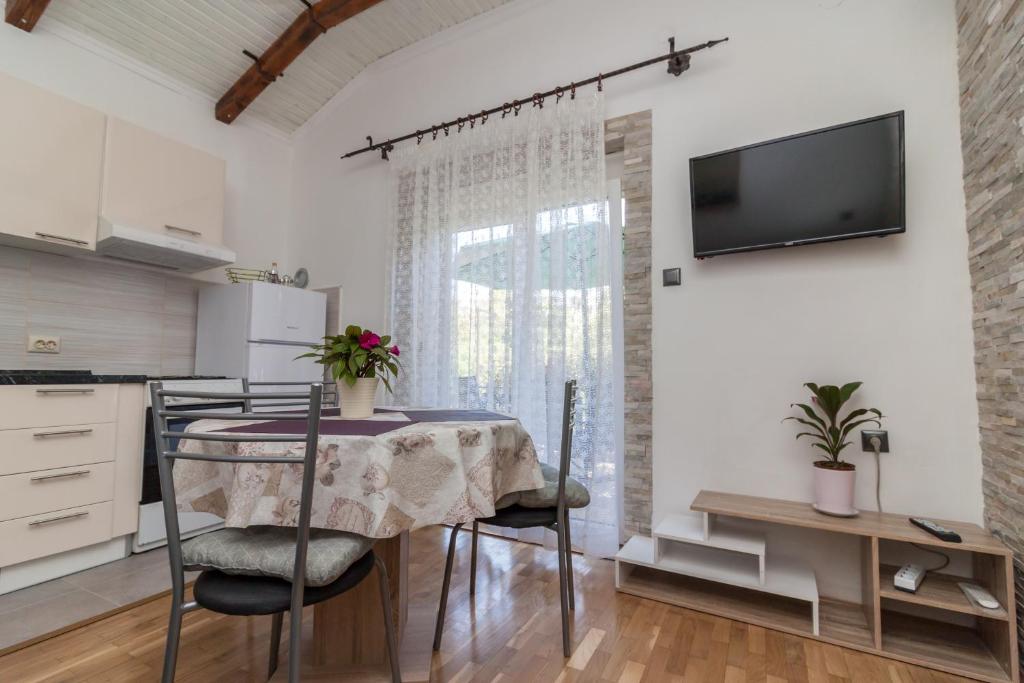 une cuisine avec une table et des chaises ainsi qu'une télévision dans l'établissement Apartment Laurel, à Rijeka