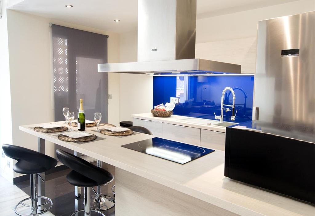 cocina con fregadero y encimera con taburetes en Edificio Plaza, en Marbella