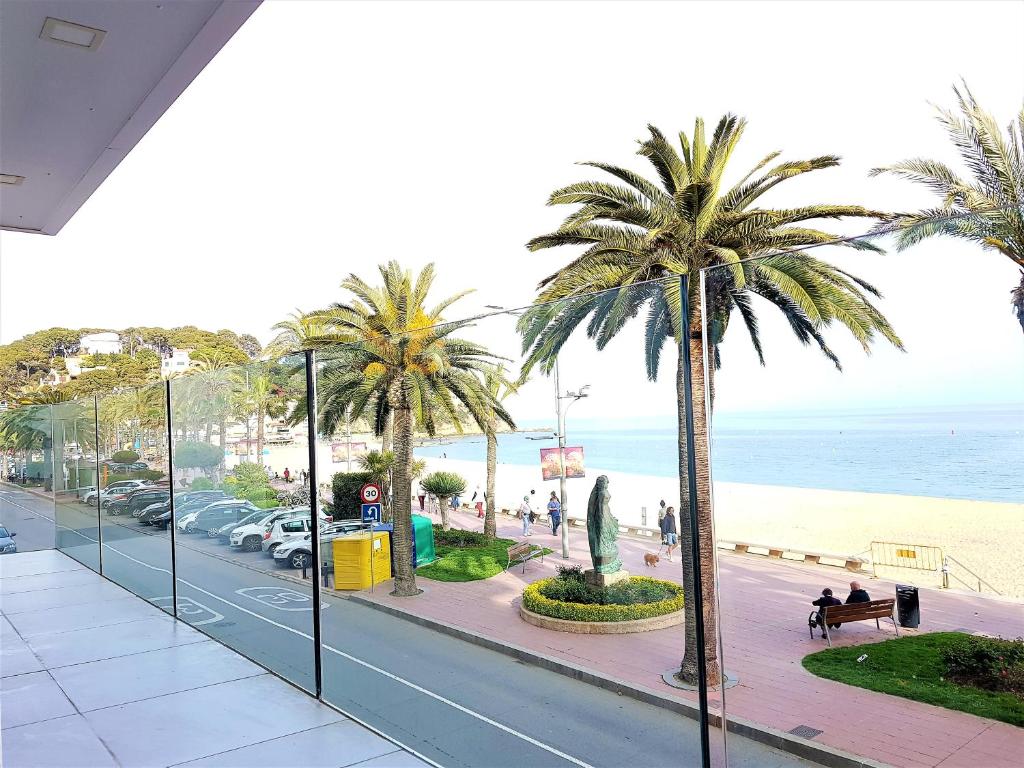a view of a street with palm trees and the beach at Lloret Paradise Apartments in Lloret de Mar