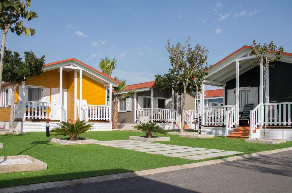 una fila de casas en una calle con césped verde en Camping Lo Monte en Pilar de la Horadada