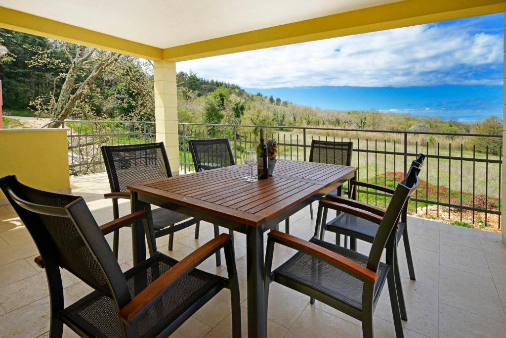 a wooden table and chairs on a patio with a view at Villa Aurelia Haus1 in Porec mit Gemeinschafts- Pool in Poreč
