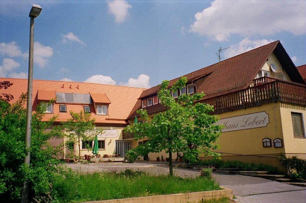 un gruppo di edifici con un albero di fronte di Landhaus Lebert Restaurant a Windelsbach