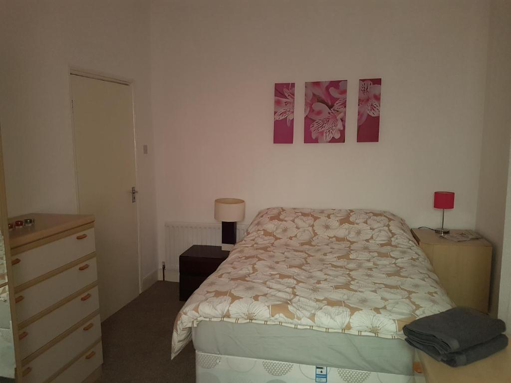 een slaapkamer met een bed en een dressoir bij AA Apartment Westoe Road in South Shields