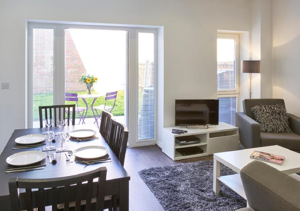 a living room with a dining table and a television at ShortstayMK Campbell Park serviced houses, with free superfast wi-fi, parking, Sky sports and movies in Milton Keynes