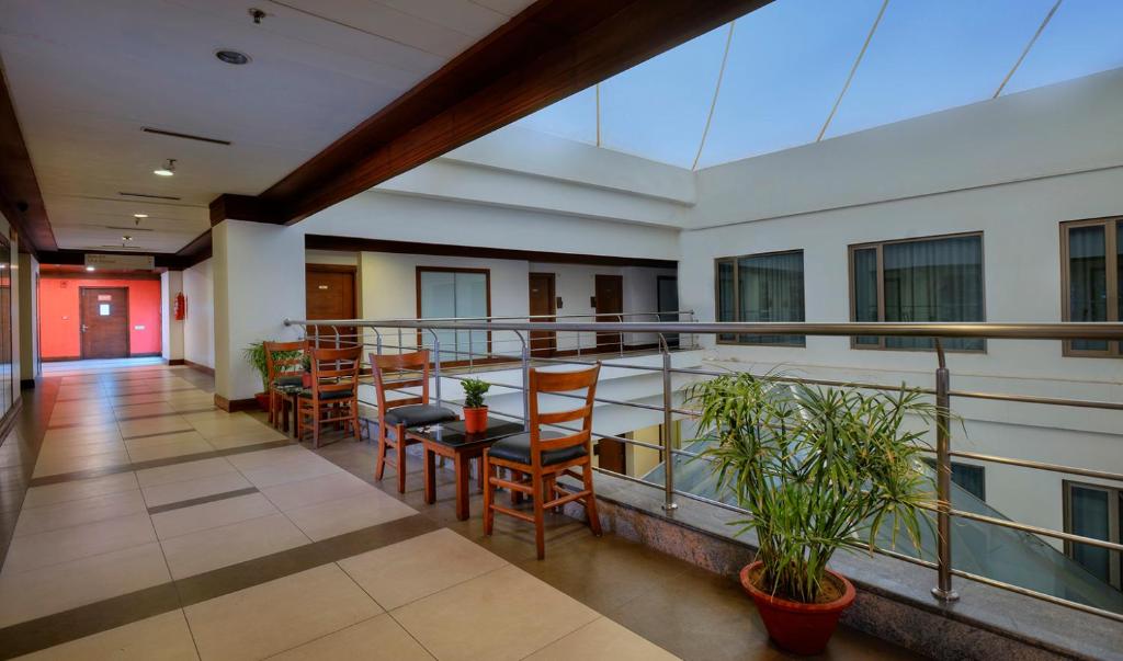 a balcony with chairs and tables in a building at Elevate by TreeHouse in Bhiwadi