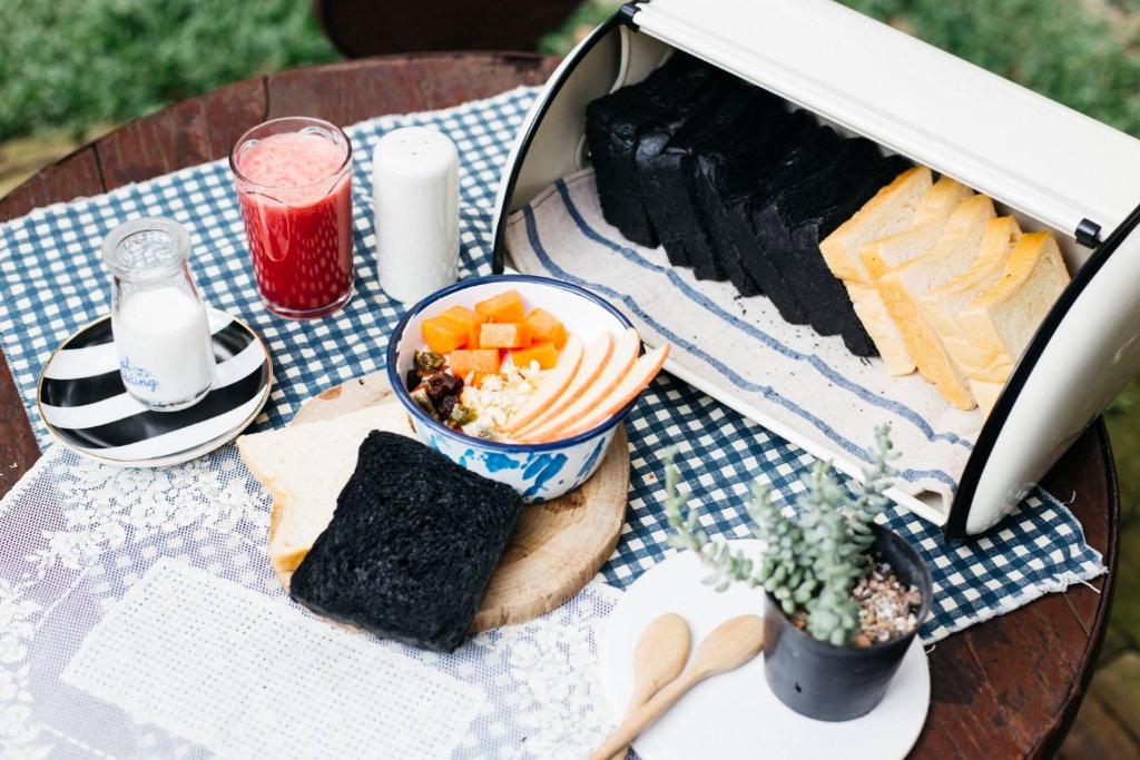 A picnic-style breakfast spread with fruit, bread, seaweed, yogurt, and juice.