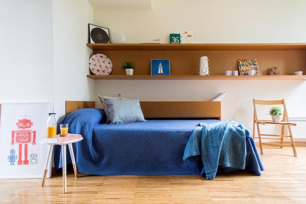 a bedroom with a bed with a blue blanket at Residencia Universitaria O Castro in Vigo