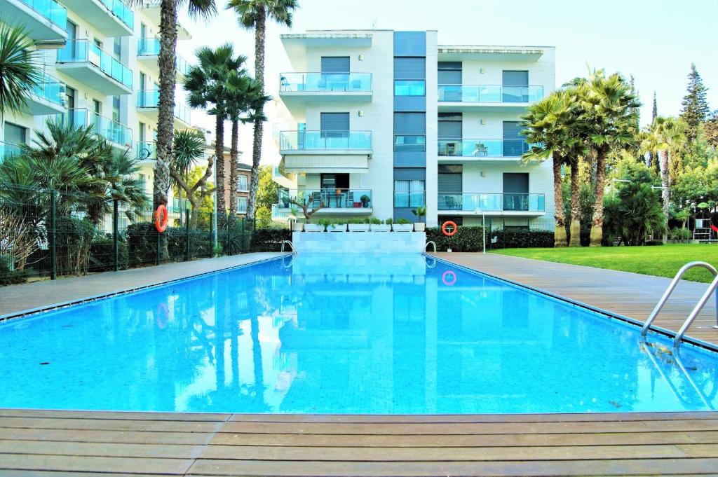 una piscina frente a un edificio de apartamentos en Apartamento Ainara Garden Family, en Lloret de Mar