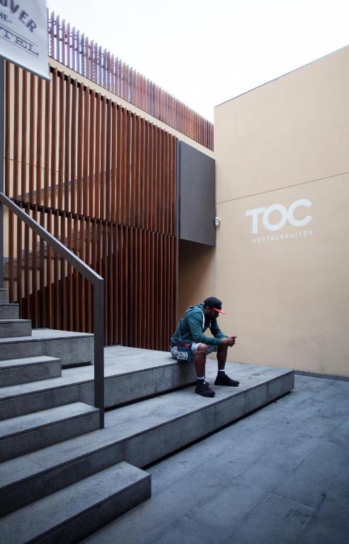 a man sitting on the steps of a building at TOC Hostel Barcelona in Barcelona