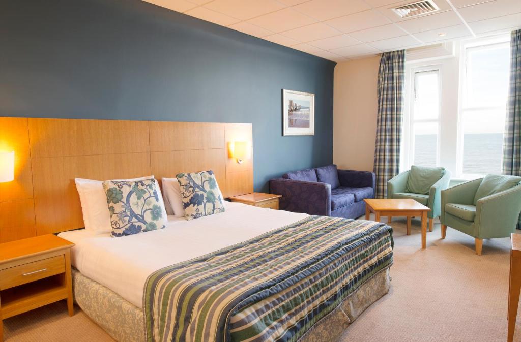 Habitación de hotel con cama y silla en Sandbanks Hotel en Poole