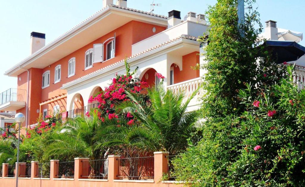 een oranje en wit huis met bloemen ervoor bij Apartamentos Concha del Mar in Sagunto