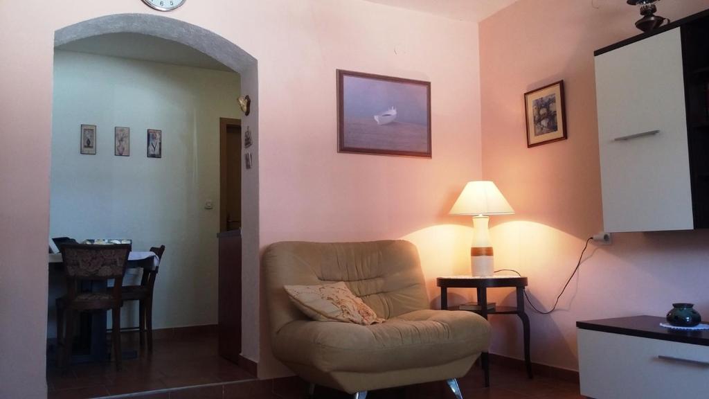 a living room with a chair and a lamp at Apartment Dante in Tisno