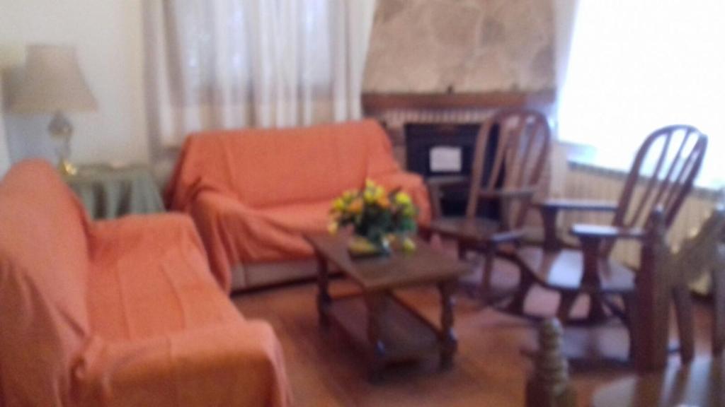 a living room with an orange couch and a table at Casa Rural del Río Tejos in El Hornillo