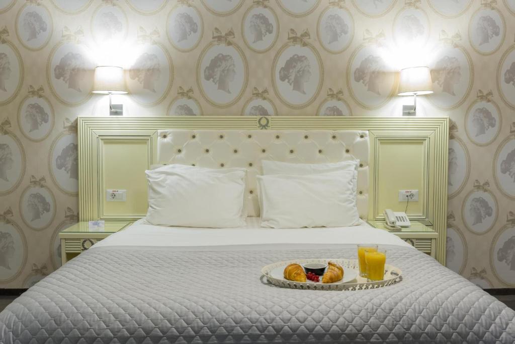 Una habitación de hotel con una cama con una bandeja de comida. en Vila Cornelia, en Bucarest