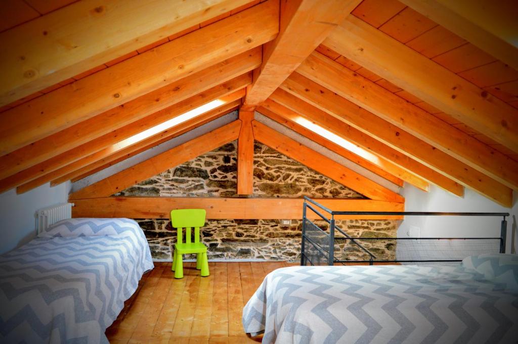 a attic room with two beds and a green stool at Casina dello Zio in Verbania