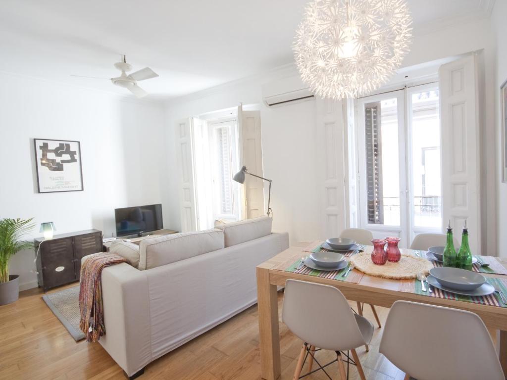 Sala de estar blanca con sofá blanco y mesa en Precioso apartamento en la latina palacio real en Madrid