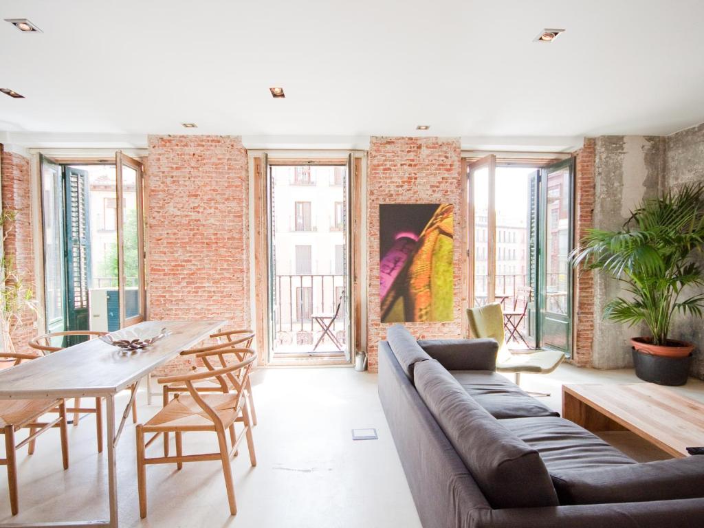 uma sala de estar com um sofá e uma mesa em Gran apartamento de diseño @plazasanmiguel *lujo* em Madri