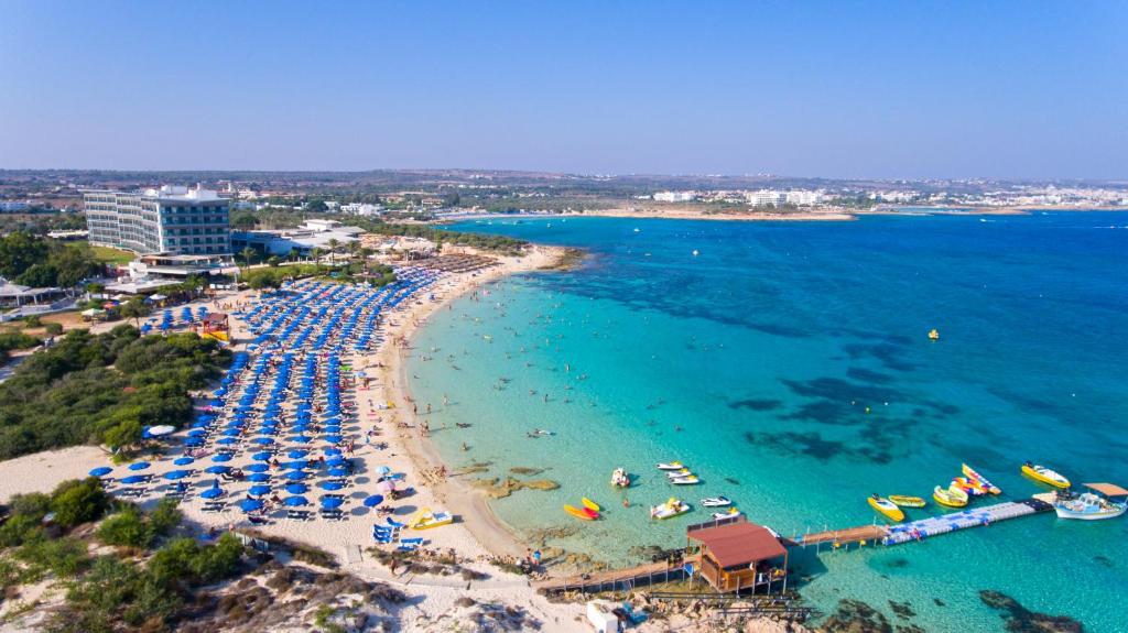 an aerial view of a beach with umbrellas and boats at Asterias Beach Hotel in Ayia Napa