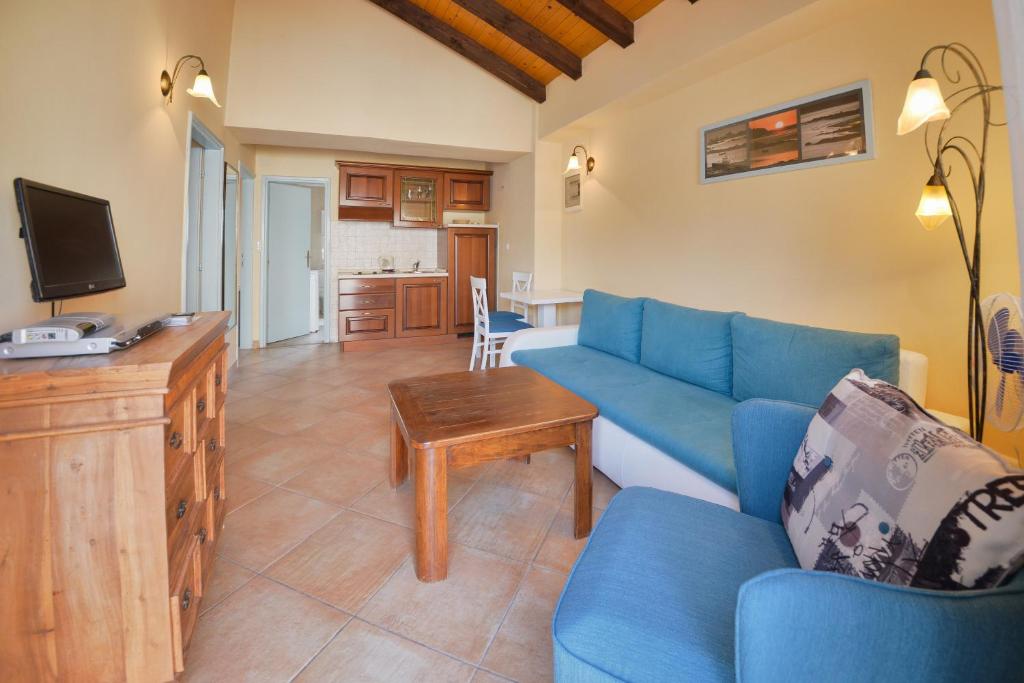 a living room with a blue couch and a tv at Kazanegra Exclusive Apartments in Sveti Stefan