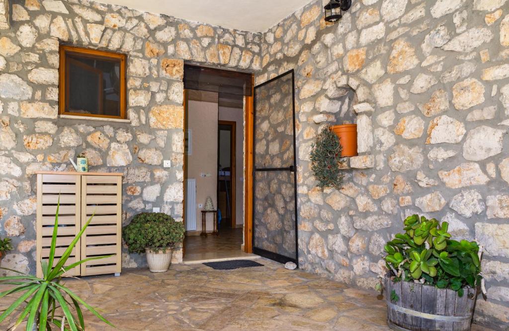 a building with a stone wall with a door at Nireas : Stone Villa in Zakynthos