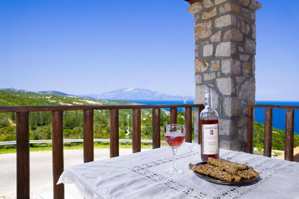 a bottle of wine and a plate of food on a table at Nireas : Stone Villa in Zakynthos