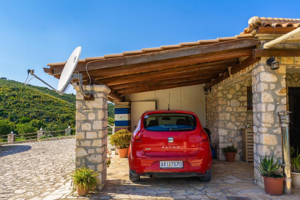 a red car parked outside of a garage at Nireas : Stone Villa in Zakynthos