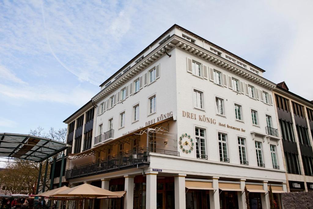 ein weißes Gebäude mit einem Schild auf der Vorderseite in der Unterkunft Kunsthotel "Drei König" am Marktplatz Stadt Lörrach in Lörrach