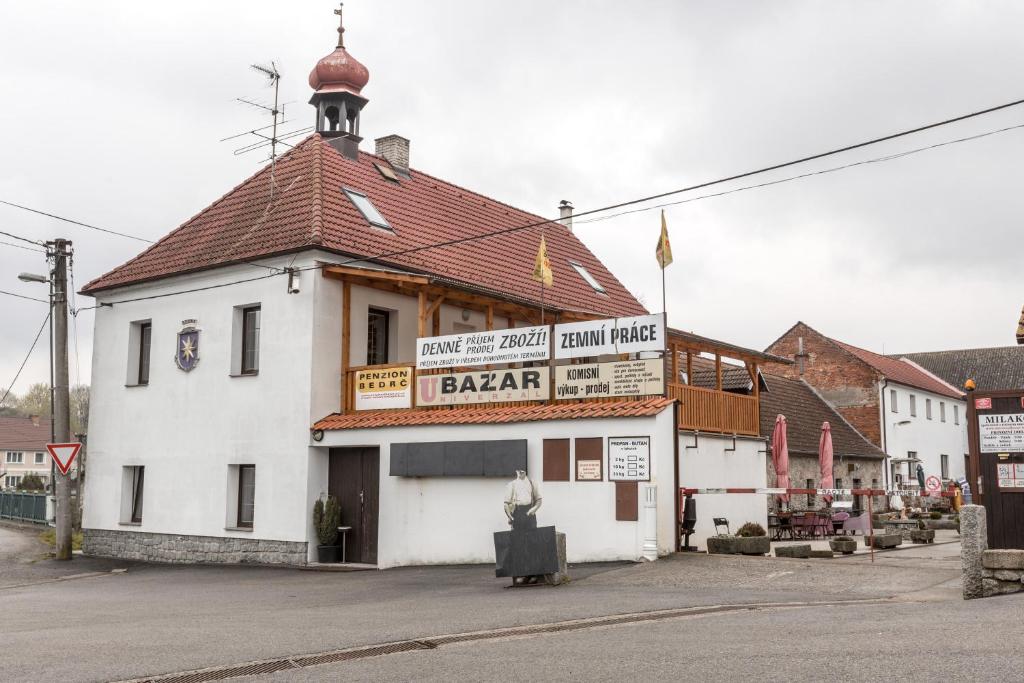 a white building with a red roof on a street at Penzion Bedrč in Benešov