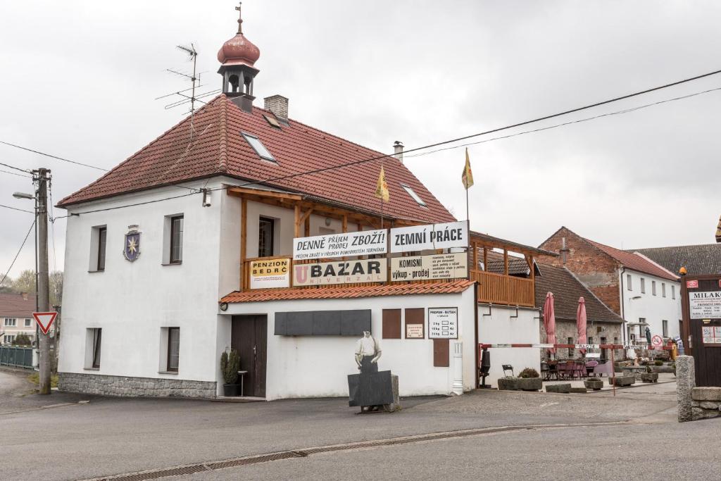 biały budynek z czerwonym dachem na ulicy w obiekcie Penzion Bedrč w mieście Benešov
