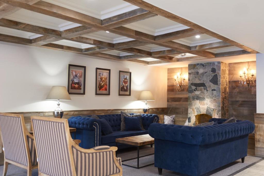sala de estar con sofás azules y chimenea en Obiekt Hotelarski Patron, en Varsovia