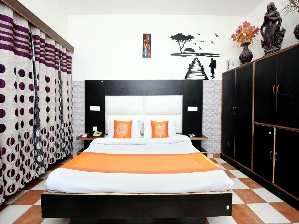 a bedroom with a large bed with orange pillows at Hotel City Plaza 7 in Chandīgarh
