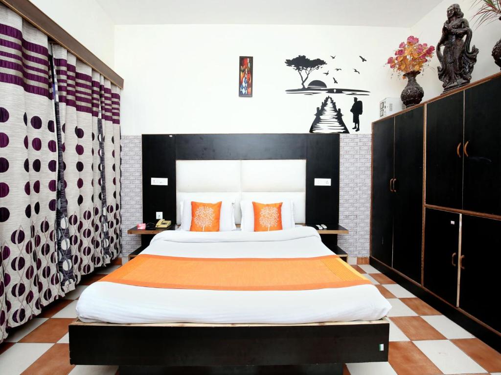 - une chambre avec un grand lit et des oreillers orange dans l'établissement Hotel City Plaza 7, à Chandigarh