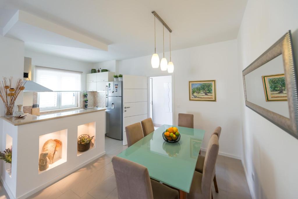 a kitchen and dining room with a green table and chairs at Apartments Estrella in Dubrovnik