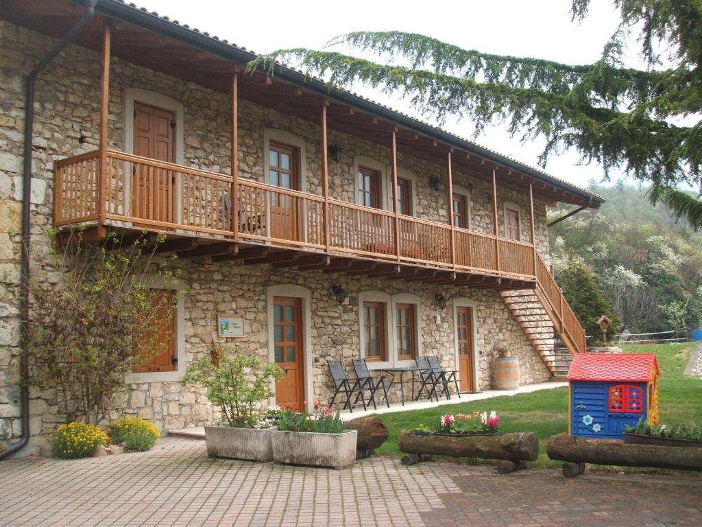 uma casa de pedra com uma varanda e um pátio em Agritur Maso Talpina em Mori