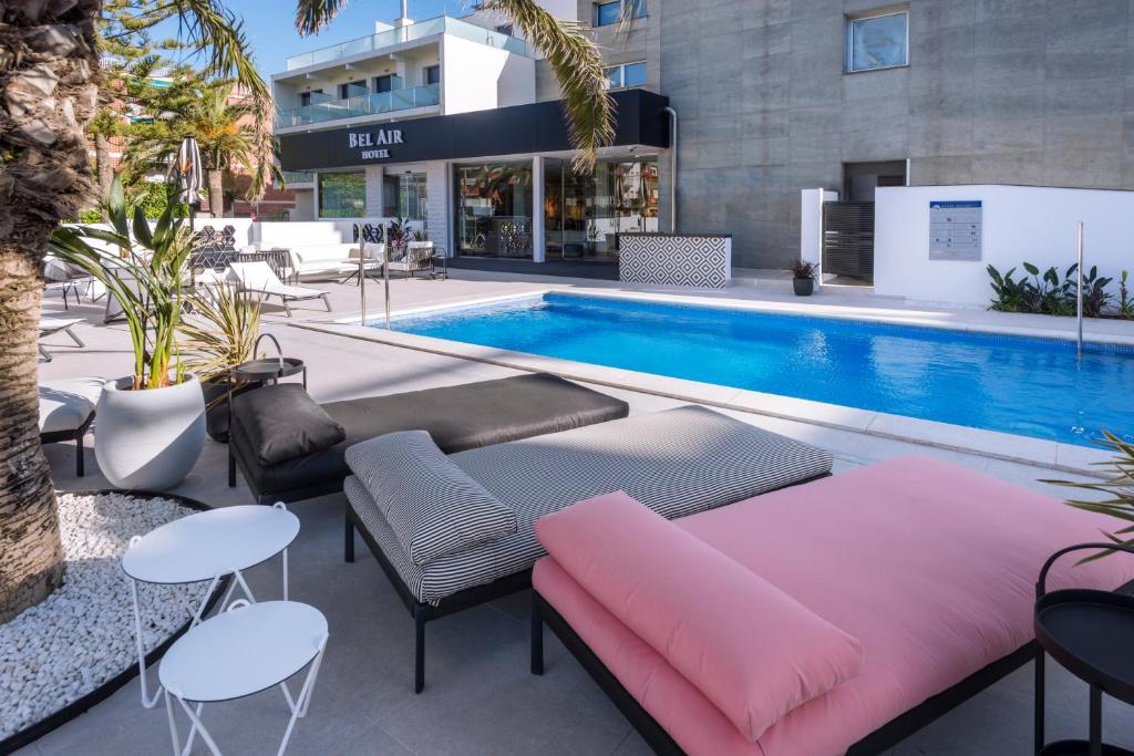 a pool with a couch and chairs next to a pool at Bel Air in Castelldefels