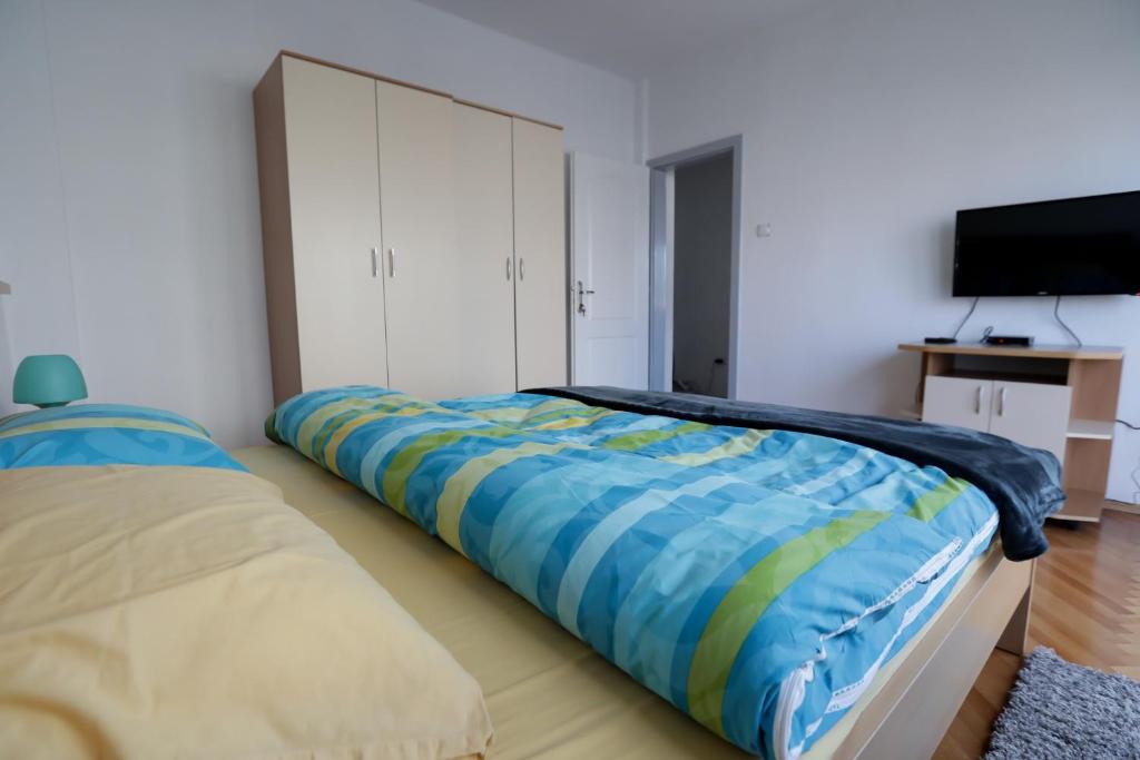 a bedroom with a bed with a blue and yellow blanket at Day&Night in Ohrid