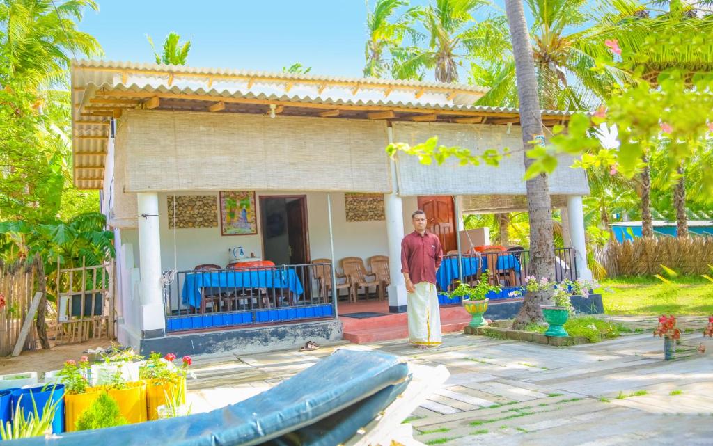 a man standing in front of a house at Oceanic White House in Nilaveli