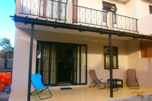 a balcony on top of a house with chairs at Residence Frangipani in Pereybere