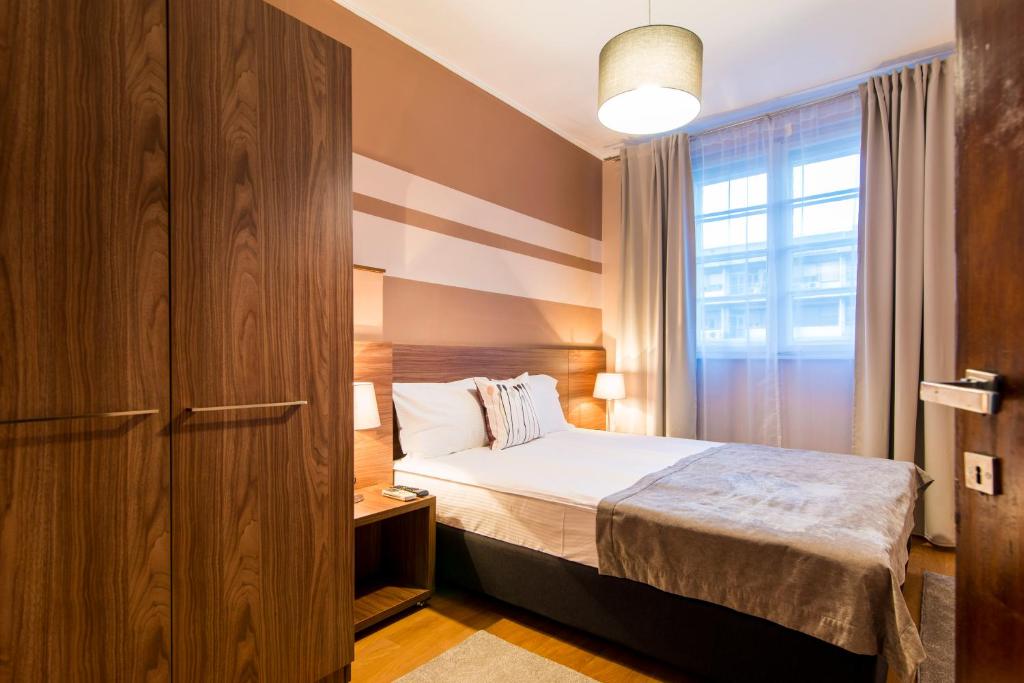 ein kleines Schlafzimmer mit einem Bett und einem Fenster in der Unterkunft Apartments Top Central 3 in Belgrad