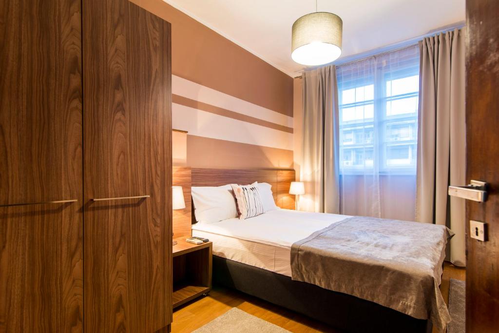 a small bedroom with a bed and a window at Apartments Top Central 3 in Belgrade