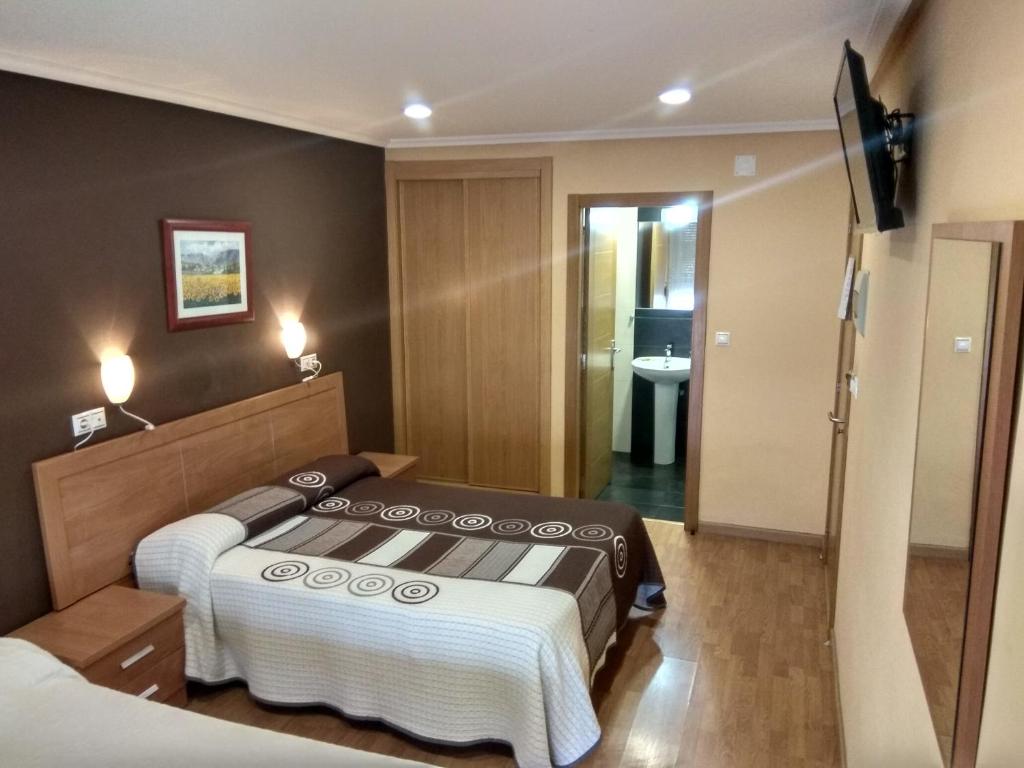 オウレンセにあるHostal Lidoのベッドとバスルーム付きのホテルルームです。