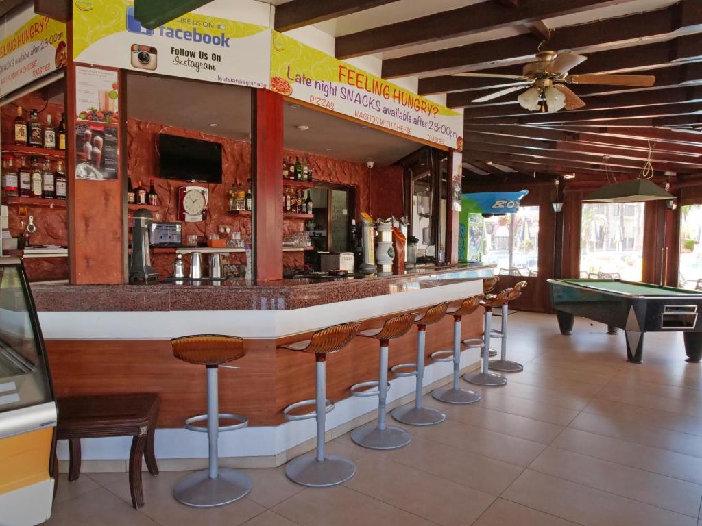 a bar with chairs and a pool table at Loutsiana Deluxe Apts in Ayia Napa