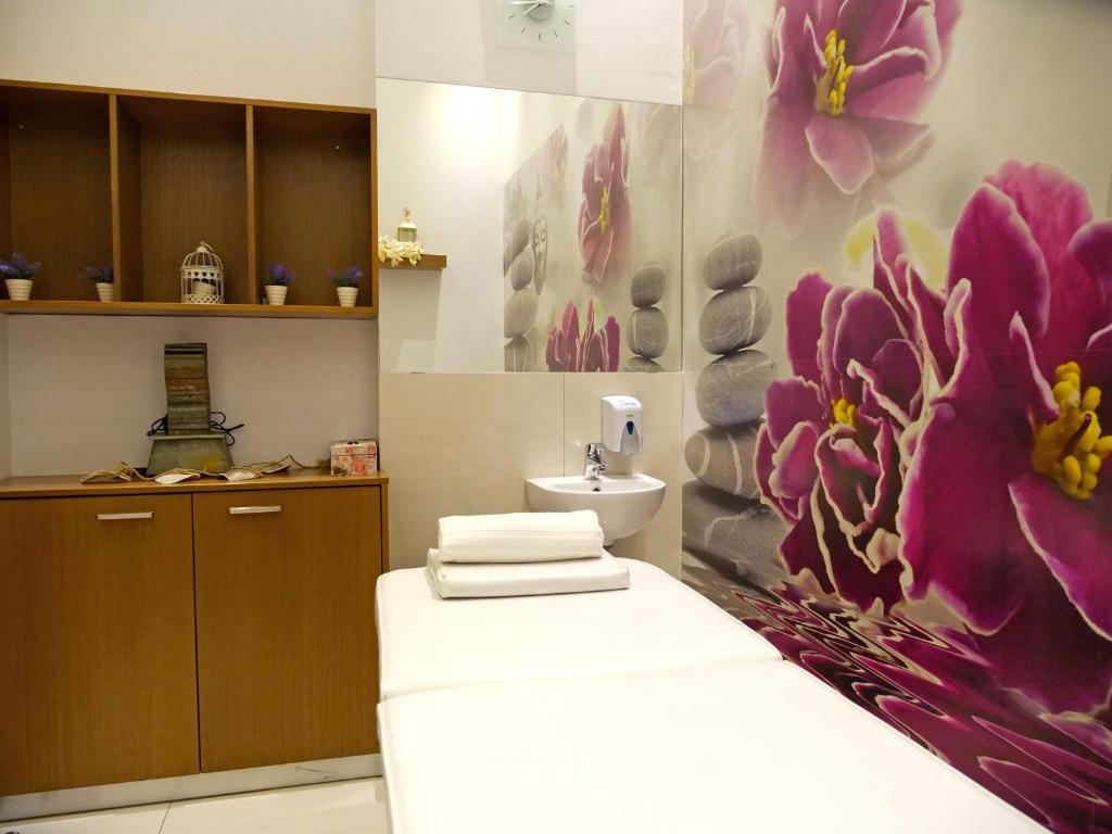 a bathroom with a flower painting on the wall at Loutsiana Deluxe Apts in Ayia Napa