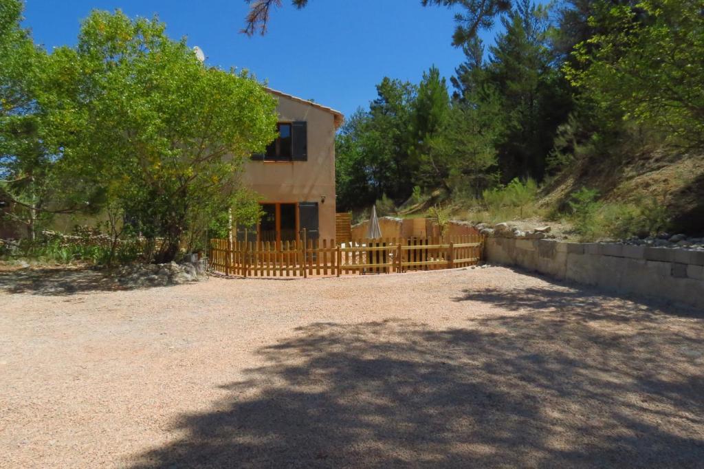 ein Holzzaun vor einem Haus in der Unterkunft Le gite du grand cèdre - proche des gorges du Verdon in Allemagne-en-Provence