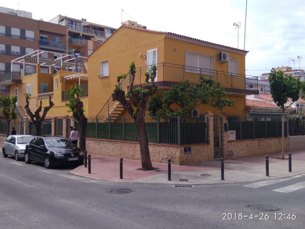 a yellow building with cars parked on the side of a street at Casa Salamanca in Benidorm