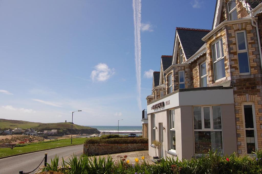 a building on the side of a road next to the ocean at The Grosvenor Guest House in Bude