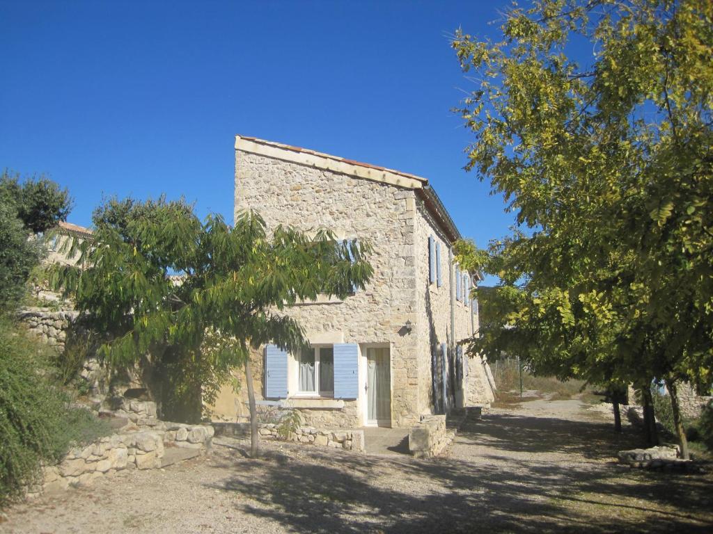 una vieja casa de piedra con árboles delante de ella en Chambres d'hôtes La Clape, en Vinon-sur-Verdon