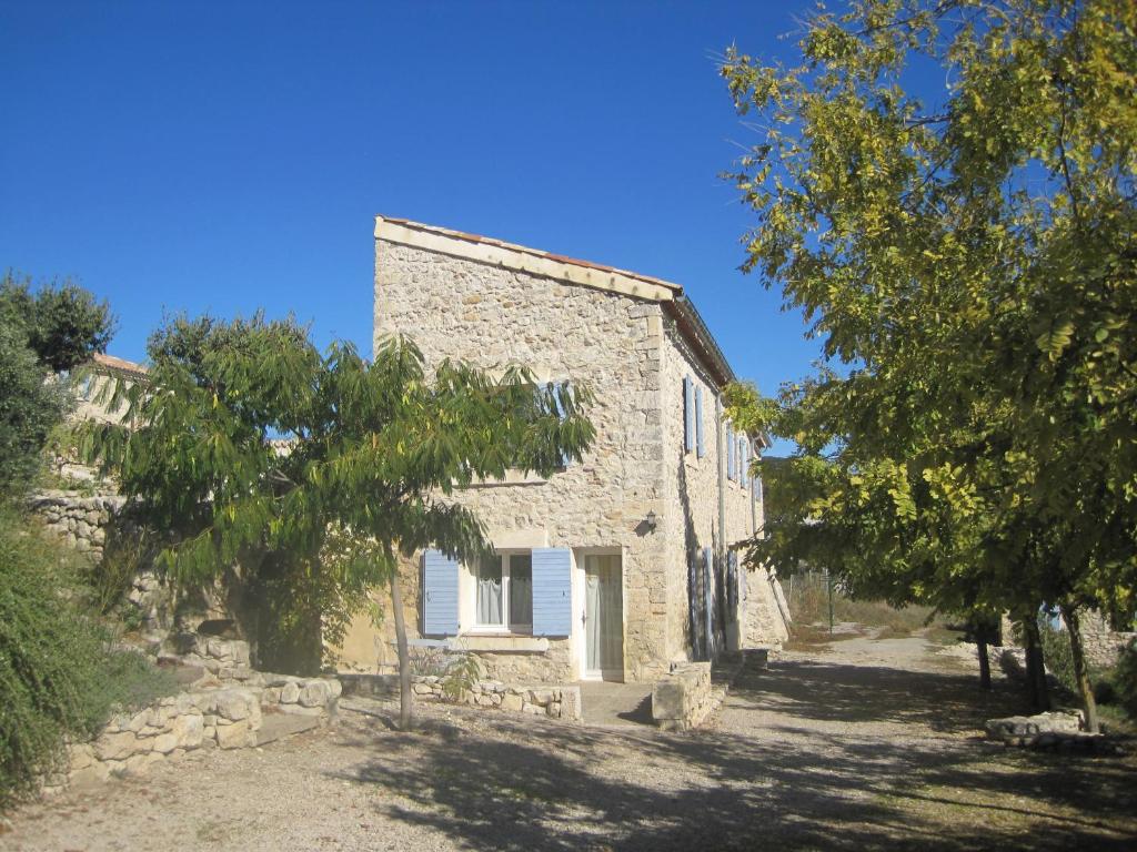une ancienne maison en pierre avec des arbres devant elle dans l'établissement Chambres d'hôtes La Clape, à Vinon-sur-Verdon