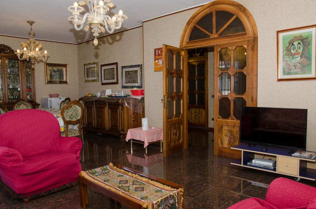 a living room with pink chairs and a tv at B&B Mamma Mia Family House in Peschiera del Garda